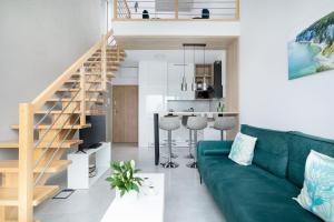 a living room with a green couch and a kitchen at Apartament Holiday Pelican in Rewal +65 photos