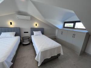 Un dormitorio abuhardillado con dos camas y una ventana. en Villa Sahra Exclusive DALYAN, en Ortaca 80 fotos más