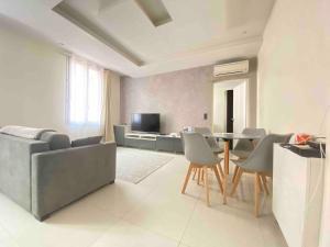 a living room with a couch and a table and chairs at Cap d ail 2 pièces proches Monaco et plage in Saint-Antoine