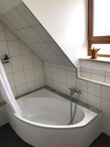 a white bath tub in a bathroom with a staircase at Ferienwohnung Weitblick - Urlaub in der Natur und trotzdem nah an Ausflugszielen in Mainleus +27 photos