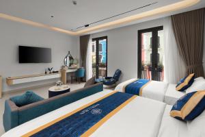 a hotel room with two beds and a television at Khue Le Bleu Villa - Đồ Sơn in Ðố Sơn