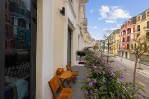 多森Khue Le Bleu Villa - Đồ Sơn的人行道上摆放着一排椅子，旁边摆放着鲜花。