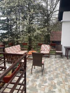 a patio with two chairs and a table and chairs at Kuca u sumi Kosmaj in Sopot +6 photos