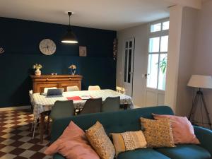 a living room with a blue couch and a table at Maison typique Bordeaux avec piscine in Bègles