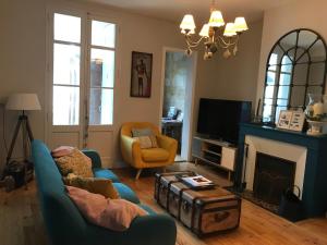 a living room with a couch and a fireplace at Maison typique Bordeaux avec piscine in Bègles