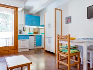 eine Küche mit blauen Schränken, einem Tisch und einem Stuhl in der Unterkunft Studio 2* Brides-les-Bains avec WIFI, 4 personnes - FR-1-512-141 in Brides-les-Bains