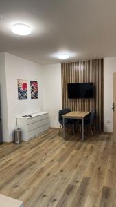 a room with a table and chairs and a television at Apartment Urban Oasis in Olomouc