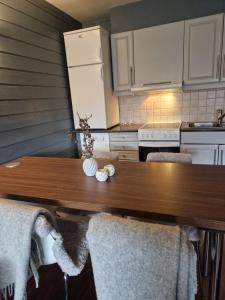 eine Küche mit einem Holztisch und weißen Geräten in der Unterkunft Storehorn Apartments Hemsedal in Fausko