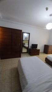 a bedroom with a large bed and a mirror at شاليه في منتجع دلتا شرم ريزورت in Sharm El Sheikh