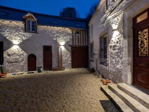 an alleyway of a white building with a wooden door at La Sourcière Beaugency in Beaugency