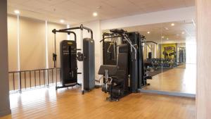 un gimnasio con varias cintas de correr y un espejo en The Matrix One Luxury Apartment Hà Nội, en Hanói