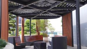 una pérgola con bancos y mesas en un patio en The Matrix One Luxury Apartment Hà Nội, en Hanói