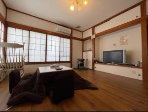 伊東市にあるHoliday House 川奈のテーブルとテレビのあるリビングルーム