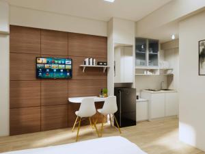 a kitchen with a table and two white chairs at Cosmy Tanglin Apartment in Surabaya