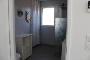 łazienka z prysznicem i toaletą oraz oknem w obiekcie La petite maison dans la pâture w mieście Vaudricourt