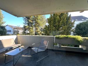 a patio with two chairs and a table at Ferienwohnung am Schwimmbad in Bad Bergzabern
