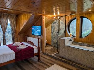 a bedroom with a bed and a tub and a tv at Casa Letca montain in Sohodol +114 photos