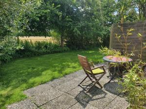 a patio with a table and a chair in a yard at Kalles kuschelige Koje in Krummendeich