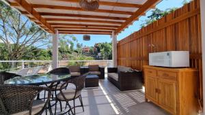 an outdoor patio with a glass table and chairs at Casa da Tieko - Suítes no Perequê in Ilhabela
