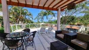 a patio with a table and chairs on a balcony at Casa da Tieko in Ilhabela