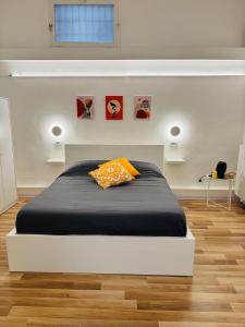 a bedroom with a bed with a orange pillow on it at Svolta Boutique in Lecce