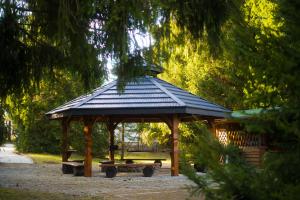 a gazebo with a picnic table in a park at Leśna Sielanka domek z jacuzzi w lesie pod Górą Szczebel RELAX I SPORT in Lubień +140 photos