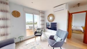 a living room with two chairs and a tv at Casa Vista in Las Casicas +3 photos
