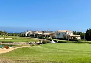 un campo da golf con un green e alcune case di 'Villa Xenia' HG25 - Relax and Enjoy the Golf Resort a Kouklia