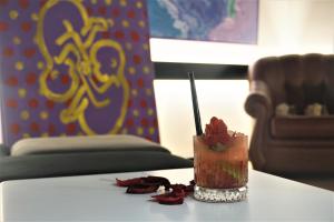 a drink on a table with rose petals on it at Dark Boutique Hotel in Tirana
