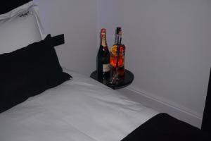 a bed with two bottles and two glasses of wine at Dark Boutique Hotel in Tirana