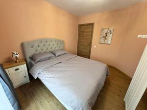 a small bedroom with a bed and a wooden floor at Spacious sunny flat with 2 bedrooms in the heart of Plovdiv in Plovdiv