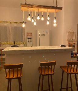 una cucina con bancone e 3 sgabelli da bar di Casa Elbacha a Trancoso