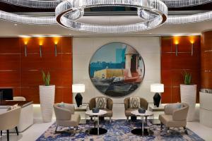 a lobby with chairs and tables and a chandelier at Hilton Dubai The Walk in Dubai