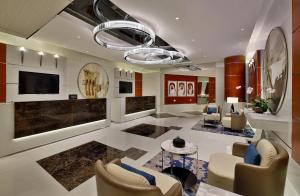 a living room with a couch and chairs and a television at Hilton Dubai The Walk in Dubai