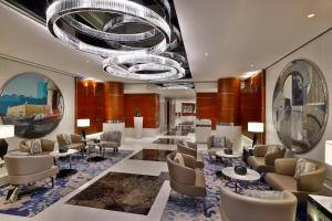 a waiting room with chairs and tables and a chandelier at Hilton Dubai The Walk in Dubai