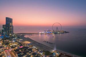 an aerial view of a city with a ferris wheel at night at Hilton Dubai The Walk in Dubai