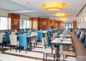 a dining room with long tables and blue chairs at Hilton Dubai The Walk in Dubai
