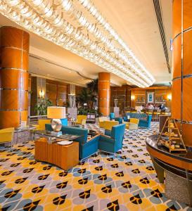a lobby with yellow and blue chairs and tables at Hilton Dubai The Walk in Dubai