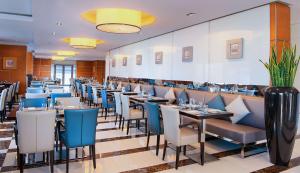 a restaurant with long tables and blue chairs at Hilton Dubai The Walk in Dubai