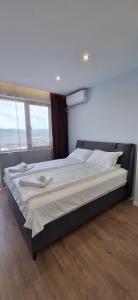 a large bed in a room with a large window at Mint 2 in Veliko Tŭrnovo