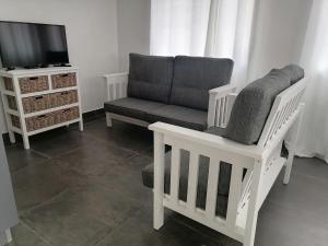 a living room with a chair and a tv at Little Seacastle in Pearly Beach