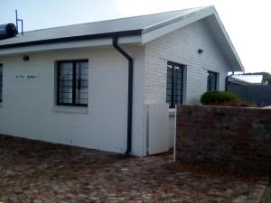 a white house with a black roof at Little Seacastle in Pearly Beach