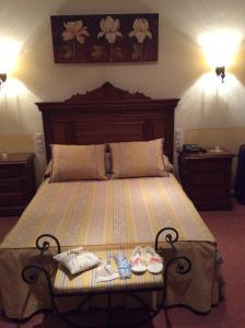 a bedroom with a large bed with shoes on it at Hotel Sandra in Alcalá de Guadaira