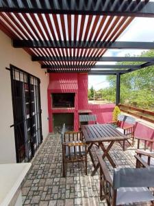 a patio with a table and chairs on a building at La casa de Yoni in Las Toninas
