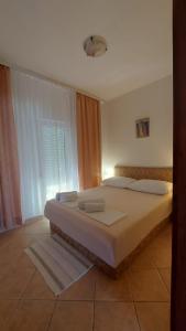 a bedroom with a large bed and a window at Apartmani Presečki in Pag