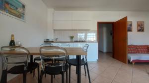 a kitchen and dining room with a table and chairs at Apartmani Presečki in Pag +77 photos