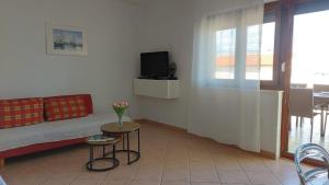 a living room with a couch and a table with a tv at Apartmani Presečki in Pag