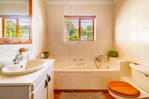 een badkamer met een bad, een wastafel en een toilet bij 5 on Paul Kruger in Somerset West