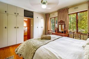 een slaapkamer met een groot bed en een spiegel bij 5 on Paul Kruger in Somerset West