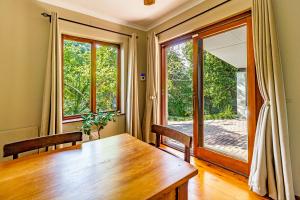 een eetkamer met een houten tafel en een groot raam bij 5 on Paul Kruger in Somerset West +7 foto's